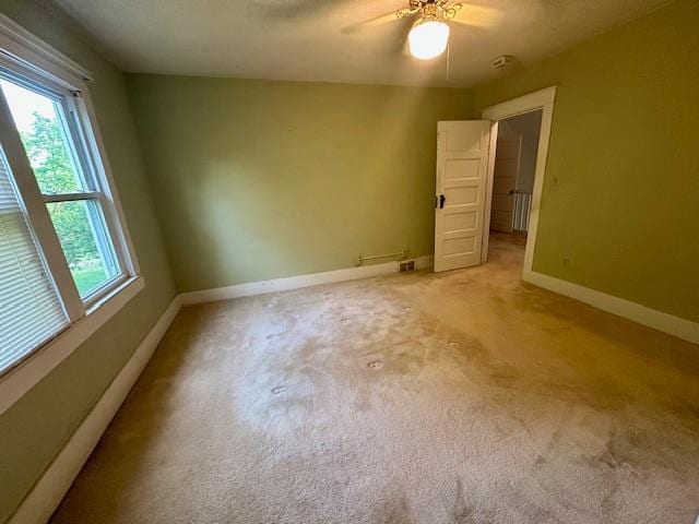 77729 330th St, Prior Twp, MN 56278 - unfurnished room featuring plenty of natural light, a ceiling fan, baseboards, and light colored carpet