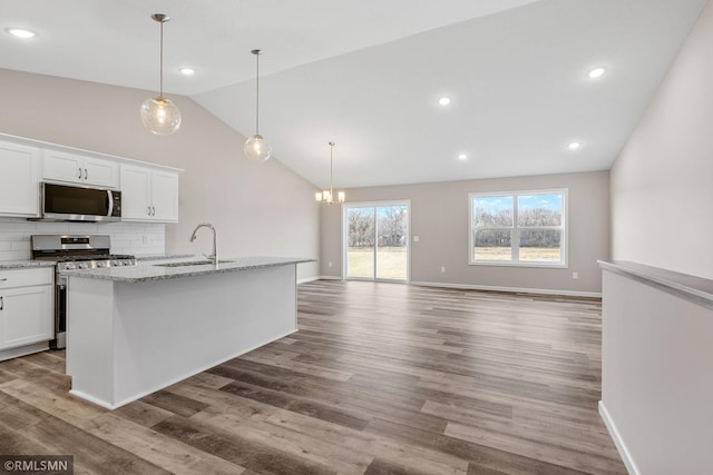 1009 2nd St NW, Delano, MN 55328 - kitchen featuring appliances with stainless steel finishes, a sink, lofted ceiling, white cabinetry, and a chandelier