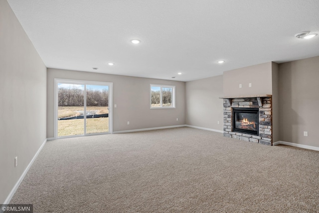 1009 2nd St NW, Delano, MN 55328 - unfurnished living room with carpet, baseboards, a fireplace, and recessed lighting