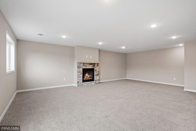 1009 2nd St NW, Delano, MN 55328 - unfurnished living room featuring carpet floors, baseboards, a stone fireplace, and recessed lighting