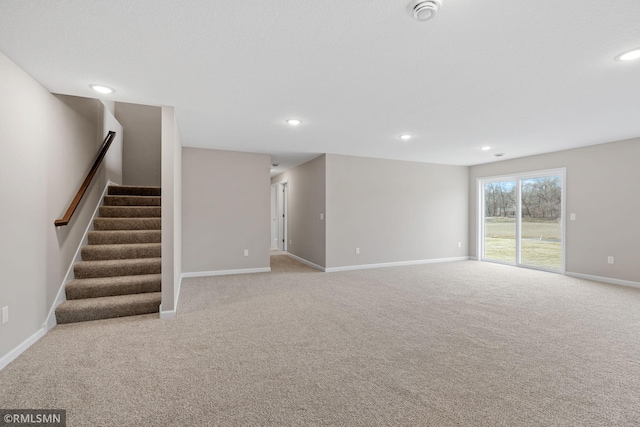 1009 2nd St NW, Delano, MN 55328 - unfurnished living room featuring carpet floors, baseboards, stairway, and recessed lighting