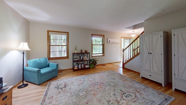 5121 Cameron Dr NW, Cascade Twp, MN 55901 - living area with light wood-style floors, baseboards, and stairway