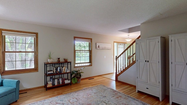 5121 Cameron Dr NW, Cascade Twp, MN 55901 - foyer with light wood-style floors, baseboards, a textured ceiling, and stairway