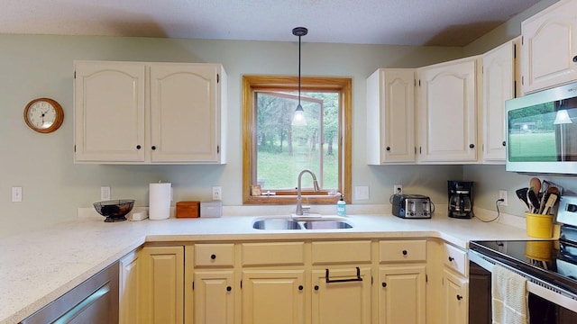 5121 Cameron Dr NW, Cascade Twp, MN 55901 - kitchen with stainless steel appliances, a sink, decorative light fixtures, white cabinetry, and light countertops