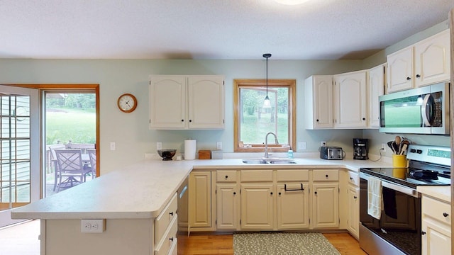 5121 Cameron Dr NW, Cascade Twp, MN 55901 - kitchen with stainless steel appliances, a sink, a peninsula, plenty of natural light, and a textured ceiling