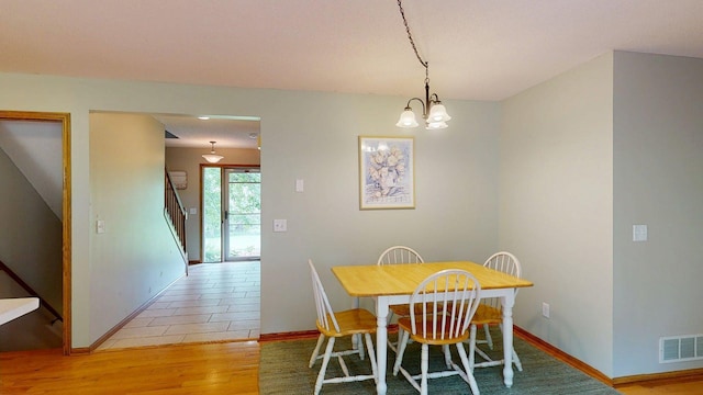 5121 Cameron Dr NW, Cascade Twp, MN 55901 - dining area with light wood-style flooring, stairway, baseboards, and a chandelier