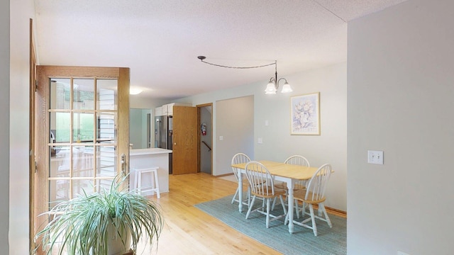 5121 Cameron Dr NW, Cascade Twp, MN 55901 - dining area with light wood-style flooring and a chandelier