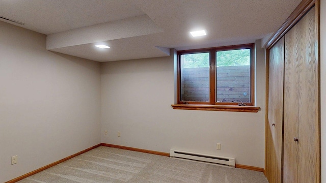 5121 Cameron Dr NW, Cascade Twp, MN 55901 - spare room featuring baseboard heating, a textured ceiling, light colored carpet, and baseboards