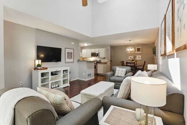 11219 16th St NE, Saint Michael, MN 55376 - living area featuring dark wood-style floors, a high ceiling, a chandelier, a ceiling fan, and baseboards
