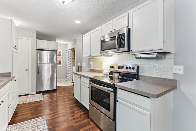 11219 16th St NE, Saint Michael, MN 55376 - kitchen featuring appliances with stainless steel finishes, dark wood-type flooring, decorative backsplash, white cabinets, and a textured ceiling