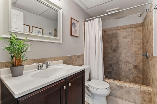 11219 16th St NE, Saint Michael, MN 55376 - bathroom featuring vanity, toilet, tiled shower, and tile walls