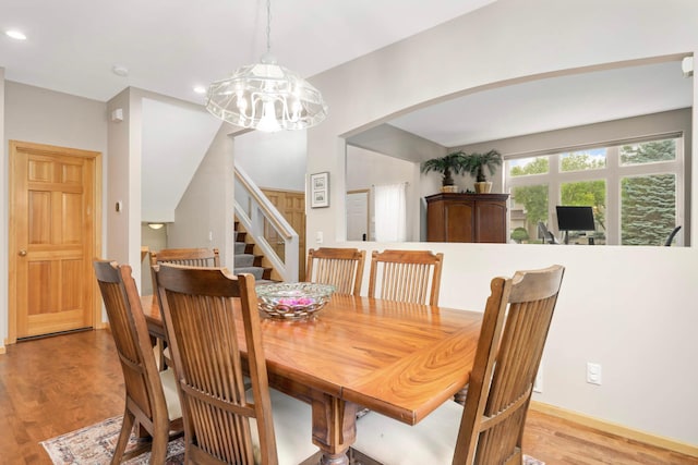 6242 Cavendish Pl, Eden Prairie, MN 55346 - dining area featuring light wood-style flooring, stairs, arched walkways, recessed lighting, and a chandelier
