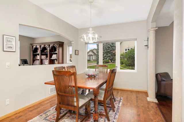 6242 Cavendish Pl, Eden Prairie, MN 55346 - dining space featuring a chandelier, arched walkways, and wood finished floors