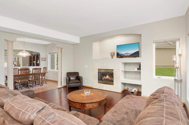 6242 Cavendish Pl, Eden Prairie, MN 55346 - living area with wood finished floors, a tile fireplace, ornate columns, and built in shelves