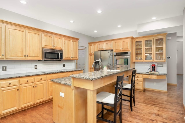6242 Cavendish Pl, Eden Prairie, MN 55346 - kitchen featuring stainless steel appliances, a breakfast bar area, decorative backsplash, stone countertops, and glass insert cabinets