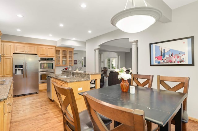 6242 Cavendish Pl, Eden Prairie, MN 55346 - dining space with decorative columns, light wood-type flooring, arched walkways, and recessed lighting