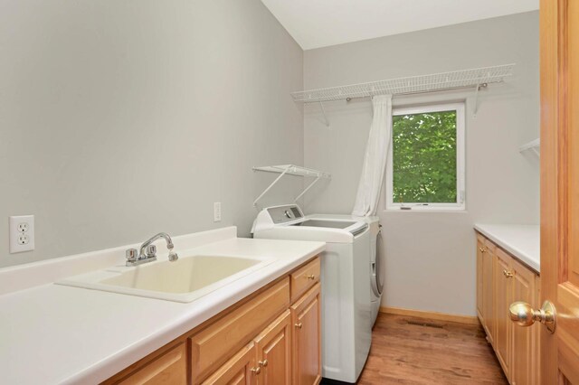 6242 Cavendish Pl, Eden Prairie, MN 55346 - laundry area featuring independent washer and dryer, light wood-type flooring, and cabinet space