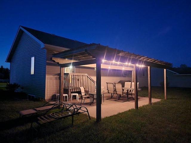 1022 Wilson Ave, Crookston, MN 56716 - patio at night with a patio, a pergola, and a lawn