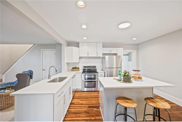 712 Anderson St W, Stillwater, MN 55082 - kitchen featuring appliances with stainless steel finishes, a sink, a kitchen breakfast bar, light countertops, and a peninsula