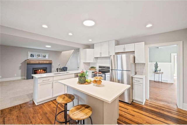 712 Anderson St W, Stillwater, MN 55082 - kitchen featuring stainless steel appliances, a sink, a peninsula, light countertops, and white cabinetry