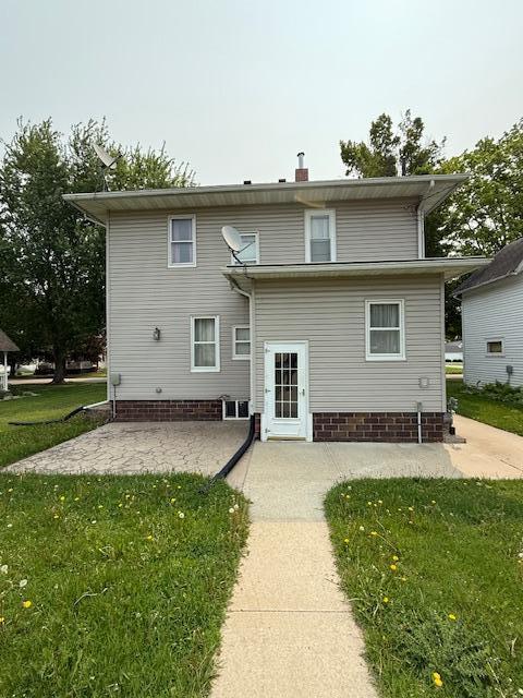 105 Oak St N, Mabel, MN 55954 - rear view of house featuring a patio area and a lawn