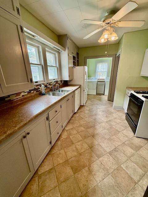 105 Oak St N, Mabel, MN 55954 - kitchen with washer and dryer, a sink, white appliances, and plenty of natural light