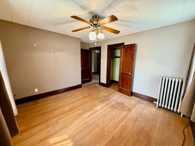 105 Oak St N, Mabel, MN 55954 - unfurnished bedroom featuring radiator, baseboards, light wood-type flooring, and ceiling fan