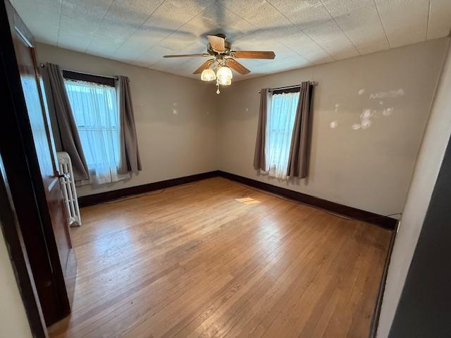 105 Oak St N, Mabel, MN 55954 - spare room with healthy amount of natural light, wood finished floors, and ceiling fan