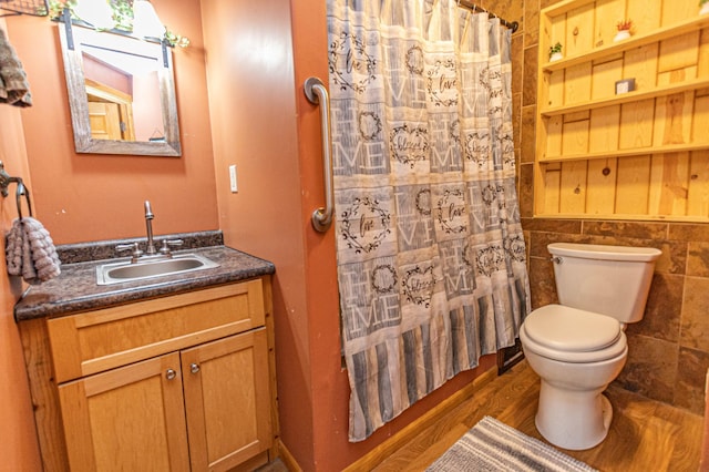 17366 Ryan Dr NE, Osakis, MN 56360 - bathroom with toilet, vanity, wood finished floors, curtained shower, and tile walls