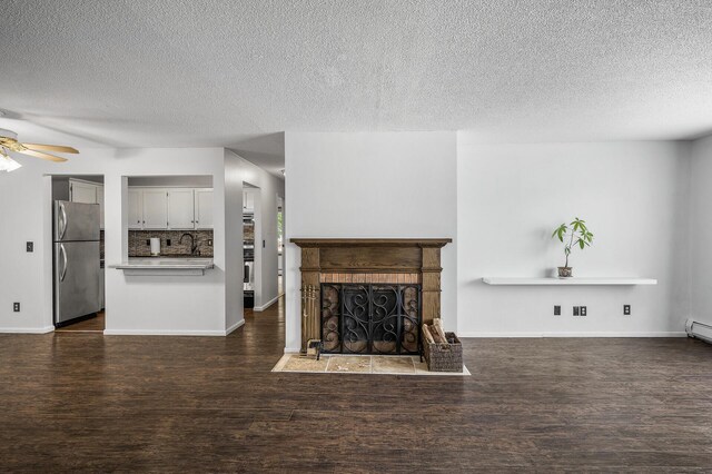 10311 Cedar Lake Rd Unit 202, Minnetonka, MN 55305 - unfurnished living room with ceiling fan, wood finished floors, a textured ceiling, a fireplace with flush hearth, and baseboards