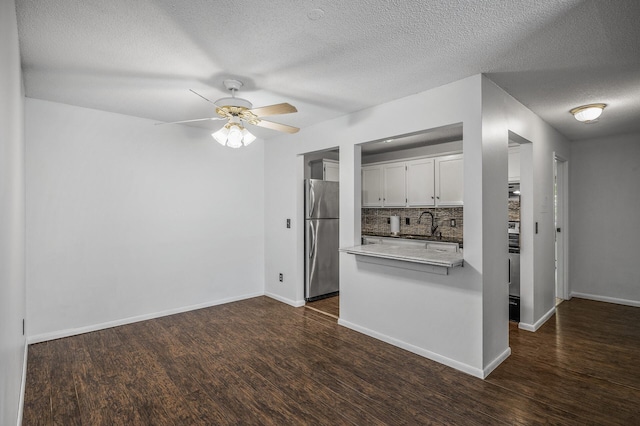 10311 Cedar Lake Rd Unit 202, Minnetonka, MN 55305 - kitchen with freestanding refrigerator, a textured ceiling, dark wood-style floors, tasteful backsplash, and a peninsula