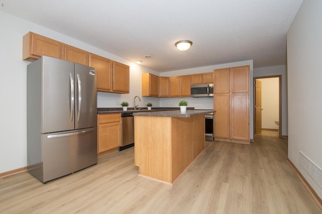 412 Cedar Pl, Maple Lake, MN 55358 - kitchen with appliances with stainless steel finishes, light wood-style floors, dark countertops, and a center island