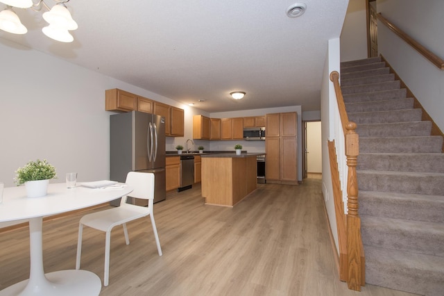 412 Cedar Pl, Maple Lake, MN 55358 - kitchen featuring stainless steel appliances, light wood-style floors, a kitchen island, a chandelier, and dark countertops