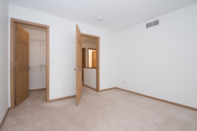 412 Cedar Pl, Maple Lake, MN 55358 - unfurnished bedroom featuring a walk in closet, light colored carpet, and a closet