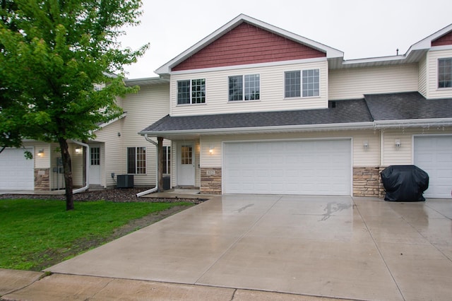 412 Cedar Pl, Maple Lake, MN 55358 - view of front facade featuring driveway, stone siding, an attached garage, a front yard, and a shingled roof