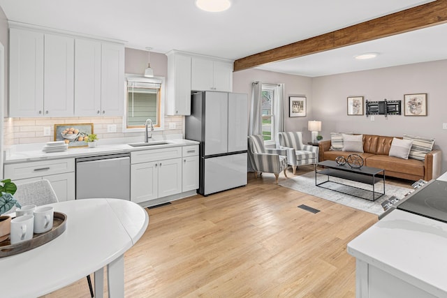 232 26th Ave N, Saint Cloud, MN 56303 - kitchen featuring freestanding refrigerator, dishwasher, open floor plan, backsplash, and light wood finished floors