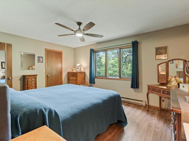 5863 Foley Rd, Baxter, MN 56425 - bedroom featuring a baseboard heating unit, wood finished floors, a textured ceiling, and ceiling fan