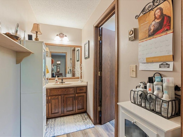 5863 Foley Rd, Baxter, MN 56425 - bathroom with a textured ceiling, vanity, and wood finished floors