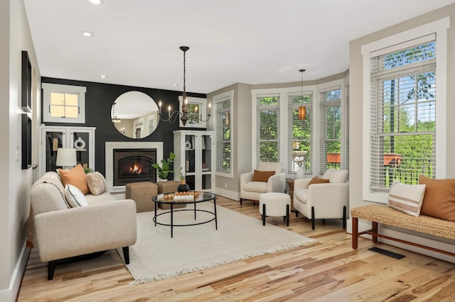 1241 Cedar Lake Rd S, Minneapolis, MN 55416 - living room with wood finished floors, a warm lit fireplace, recessed lighting, baseboards, and a chandelier