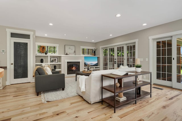 1241 Cedar Lake Rd S, Minneapolis, MN 55416 - living area featuring french doors, light wood finished floors, a glass covered fireplace, and recessed lighting