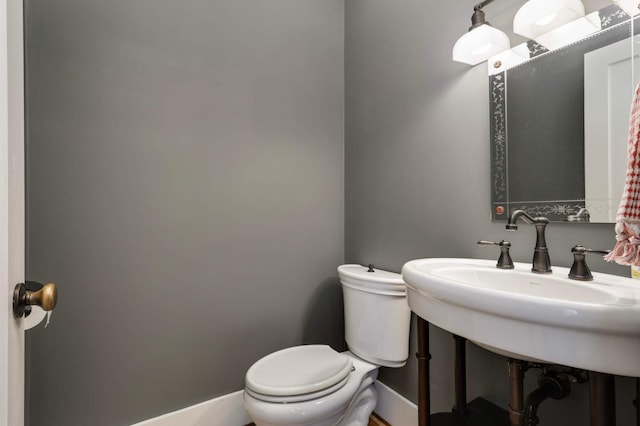 1241 Cedar Lake Rd S, Minneapolis, MN 55416 - half bathroom featuring toilet, baseboards, and a sink