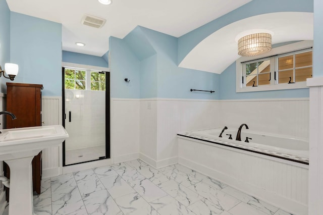 1241 Cedar Lake Rd S, Minneapolis, MN 55416 - full bathroom with marble look tile flooring, a wainscoted wall, a bath, a shower stall, and baseboards
