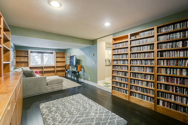 1241 Cedar Lake Rd S, Minneapolis, MN 55416 - living area featuring a textured ceiling, wall of books, wood-type flooring, baseboards, and recessed lighting