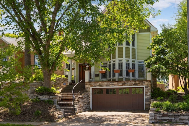 1241 Cedar Lake Rd S, Minneapolis, MN 55416 - view of front of home featuring an attached garage, stone siding, stairway, and concrete driveway