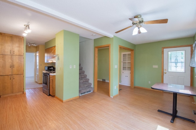 1618 10th St N, Fargo, ND 58102 - kitchen featuring stainless steel stove, light wood-style floors, a ceiling fan, brown cabinetry, and baseboards