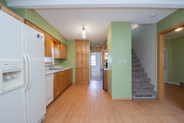 1618 10th St N, Fargo, ND 58102 - kitchen with white appliances, a sink, light wood finished floors, light countertops, and brown cabinetry