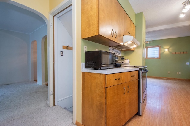 1618 10th St N, Fargo, ND 58102 - kitchen featuring stainless steel range with electric cooktop, black microwave, arched walkways, light countertops, and baseboards