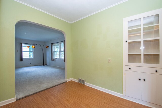 1618 10th St N, Fargo, ND 58102 - spare room featuring arched walkways, light wood-style flooring, baseboards, and ornamental molding
