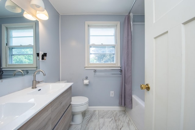 1618 10th St N, Fargo, ND 58102 - full bathroom with double vanity, marble finish floors, shower / tub combo with curtain, toilet, and baseboards