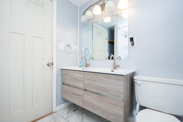 1618 10th St N, Fargo, ND 58102 - full bathroom featuring marble look tile flooring, double vanity, toilet, and baseboards